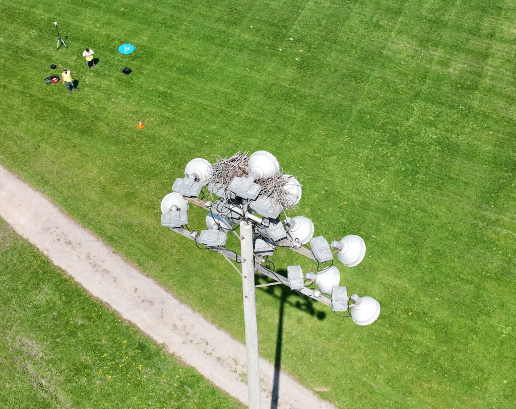 Drone infrastructure inspection of stadium light tower with bird nest buildup in Southern Ontario